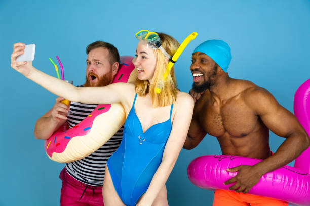 istock Happy young friends resting on blue studio background 1196038820