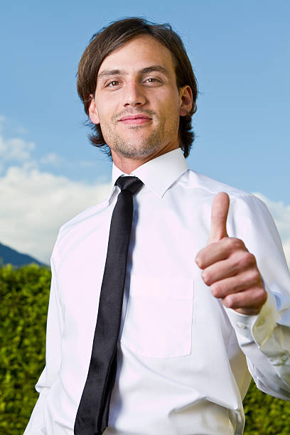 Thumbs up over blue skies stock photo