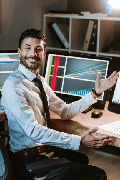 istock smiling bi-racial trader with outstretched hand looking at camera 1196043148