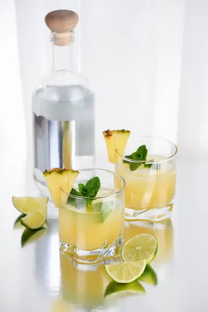 Vodka cocktail with pineapple juice, a slice of lime, cooled with ice and mint