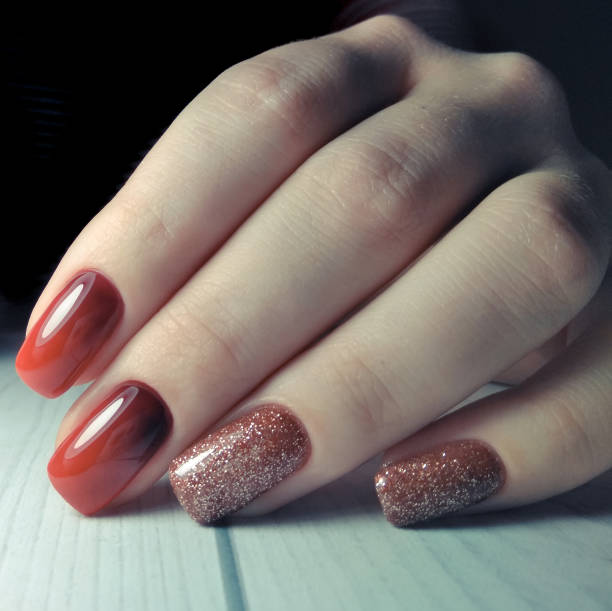 istock Long square nails covered with gel Polish with gradient design on wooden background. Red gradient on the nails. From black to red. Brilliant design. 1196044318