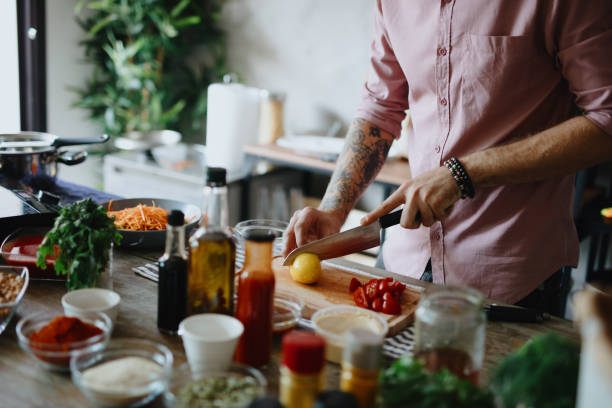 istock Man cutting and squeezing lemon into bowl 1196045216