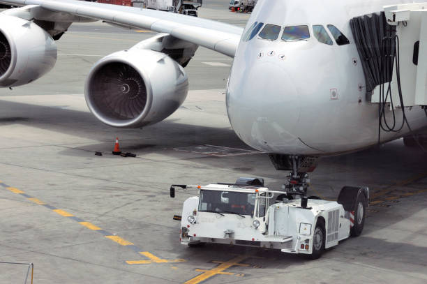istock airplane on airport runway with pushback tractor 1196046522