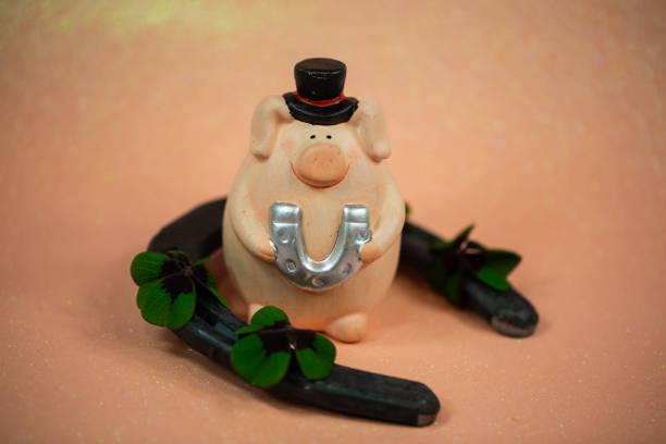 istock lucky pig on pink background on horseshoes 1196048513