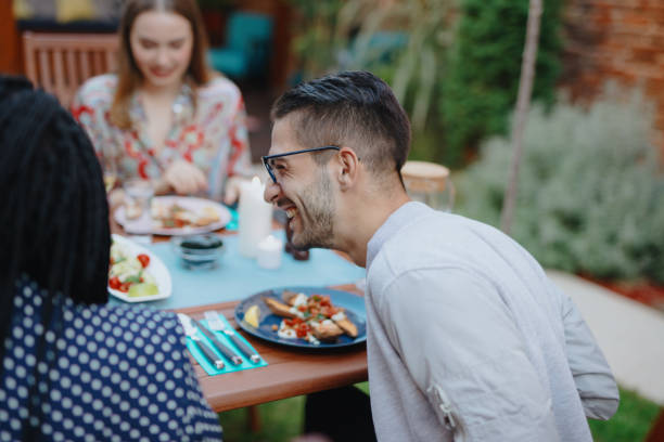 istock Dinner party guests talking at the table and eating 1196049000