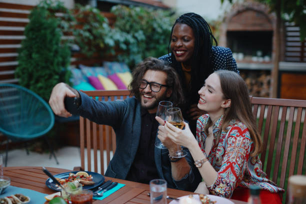 istock Smiling group of young people taking selfie while having dinner with friends 1196049552