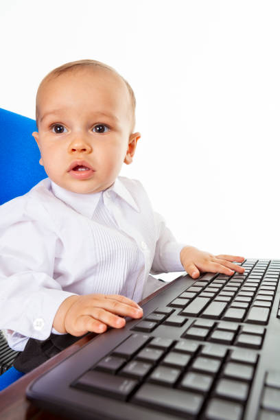 One year old caught working on a computer stock photo