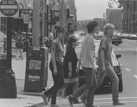 This image is of a group of young people dressed in the style of the mid 1980s Boston Music scene walking down Newbury Street in Boston.