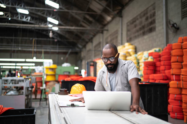 ingenieur arbeitet in der fabrik mit laptop - engineer manufacturing occupation manual worker factory stock-fotos und bilder