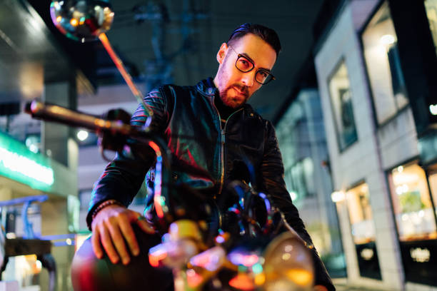 Portrait of handsome motorbike rider at night A portrait of a handsome male motorbike rider in the street at night. low angle street japan stock pictures, royalty-free photos & images