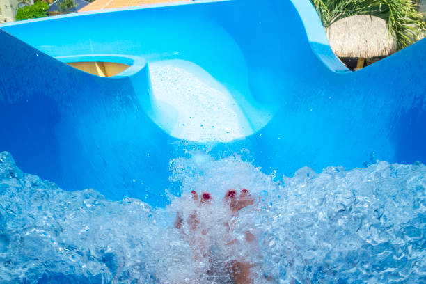Top of a Waterslide at Resort Hotel Feet Showing This picture shows the entrance to a waterslide. This slide was found at a resort hotel. A rider's bare feet with painted toenails is shown before the launch down the slide. top of water slide photos stock pictures, royalty-free photos & images