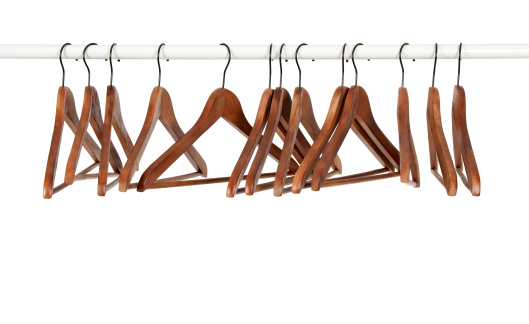 Many wooden hangers on a rod, isolated on white background.