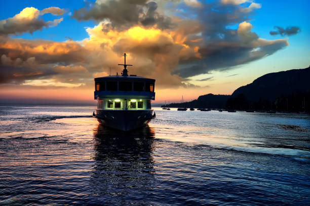 ガルダ市の遊歩道でガルダ湖の素晴らしい夕日に旅客船 - lake garda sunset blue nautical vessel ストックフォトと画像