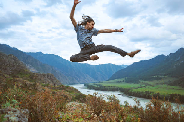 istock guy jumps on top of a mountain 1196064846