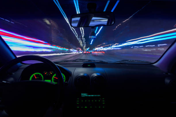 istock View of the moving lights from inside a car through the windshield at night. Long exposure. 1196065932