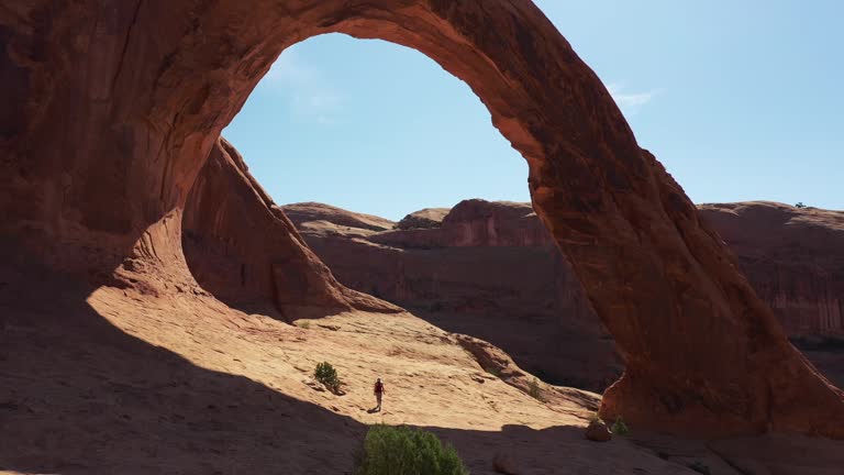 Drone view: woman hiking by Corona arch, Moab, Utah