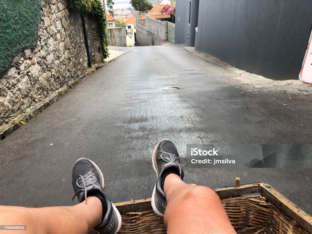 Sliding down the street, Funchal, Madeira, Portugal The traditional Basket Sledge Riding from Monte down to the old town of Funchal on the Island of Madeira in the Atlantic Ocean of Portugal. Funchal Stock Photo