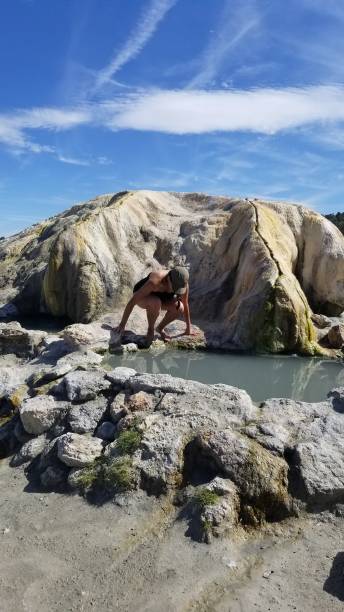 istock Woman climbs into a natural hot spring 1196070026