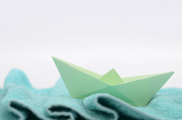 istock Hand crafted paper boat on fabric waves 1196071580