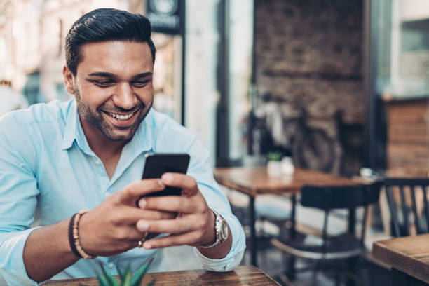 istock Smiling businessman texting in cafe 1196074354