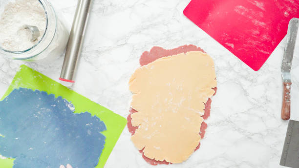 istock Rolling out dough with a rolling pin to bake red, white, and blue pinwheel 1196074425