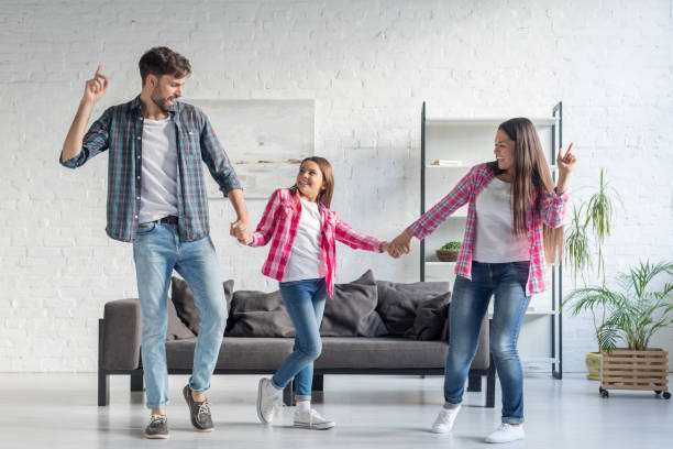 istock Happy family dancing at home 1196076018