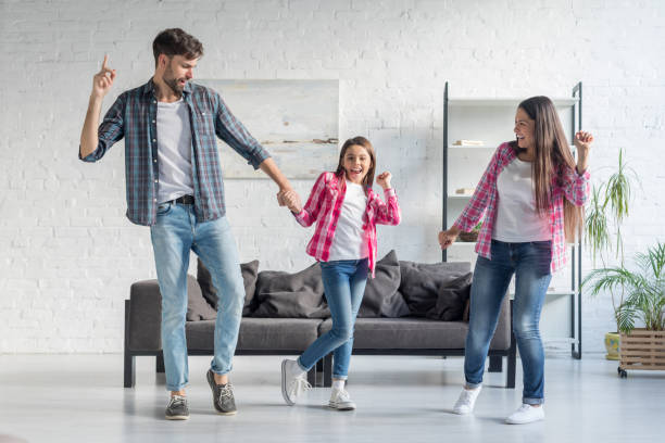 istock Happy family dancing at home 1196076055