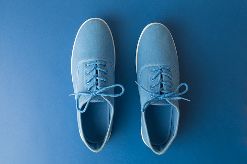 Pair of shoes on classic blue background minimal creative clothing and fashion concept.