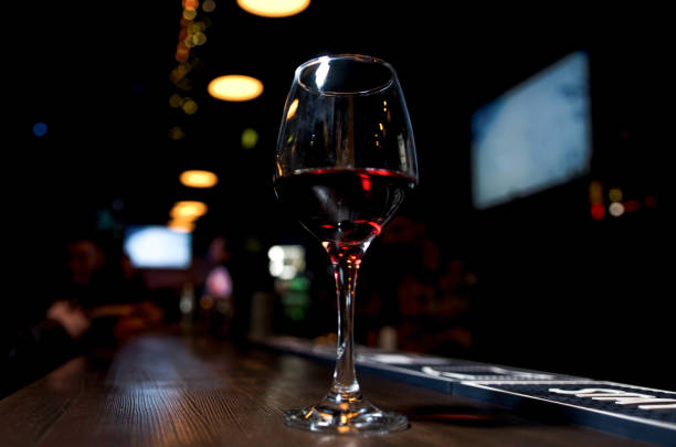 istock Glass of red wine on backlighted background 1196077957