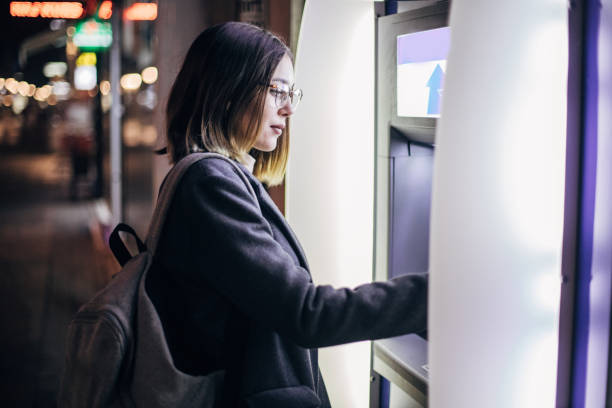 istock Young woman is withdrawing money from ATM machine 1196078220