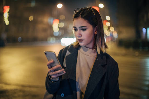 istock Cute young woman is using mobile phone 1196079483