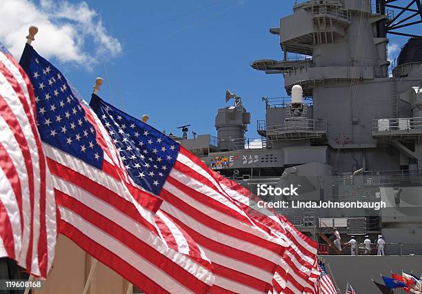 Us Flags Beside Battleship Missouri Memorial With Four Sailors Stock Photo - Download Image Now