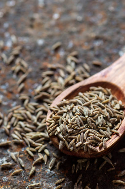 istock Cumin seeds in wooden spoon on a textured background 1196083876