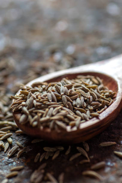istock Cumin seeds in wooden spoon on a textured background 1196083931