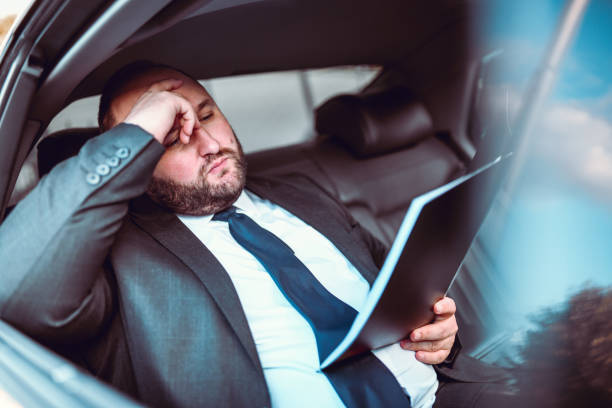 istock Tired Businessman Napping In Car After Work 1196084003