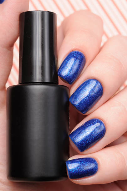 istock Winter blue manicure with shimmer on red lines candy background 1196085162