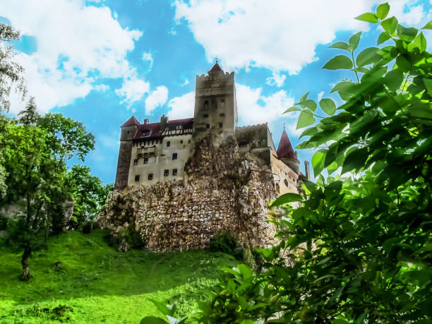 bran castle in the sun rays on a background of blue sky and green nature - vlad vi imagens e fotografias de stock