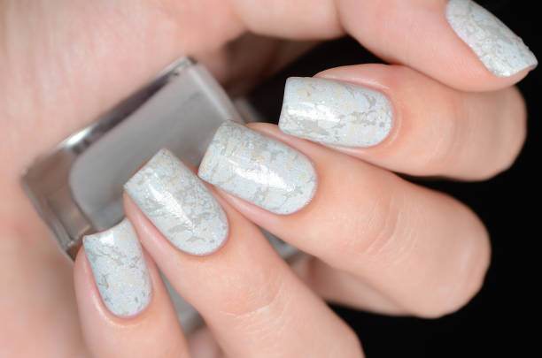 istock grey manicure with marblre effect with shimmer on a black background 1196088742