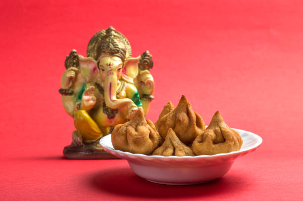 Indian Food: Modak with idol of lord Ganesha, Maharashtra Sweet Dish, greeting card design. Indian Food: Modak with idol of lord Ganesha, Maharashtra Sweet Dish, greeting card design. dharma stock pictures, royalty-free photos & images
