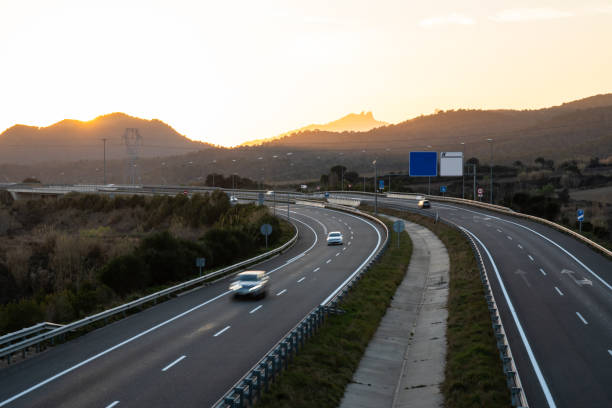 istock Cars in motion on highway during sunset with copy space and custom signs 1196093009