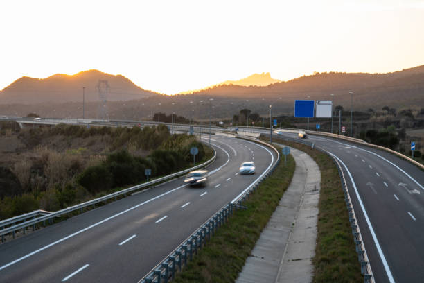 istock Cars in motion on highway during sunset with copy space and custom signs 1196093036