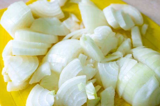 istock Chopped onion on a yellow cutting board. 1196093723