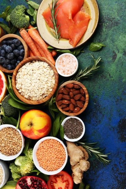istock Healthy food clean eating selection: fish, fruit, vegetable, cereal, leaf vegetable on rustic background 1196094386