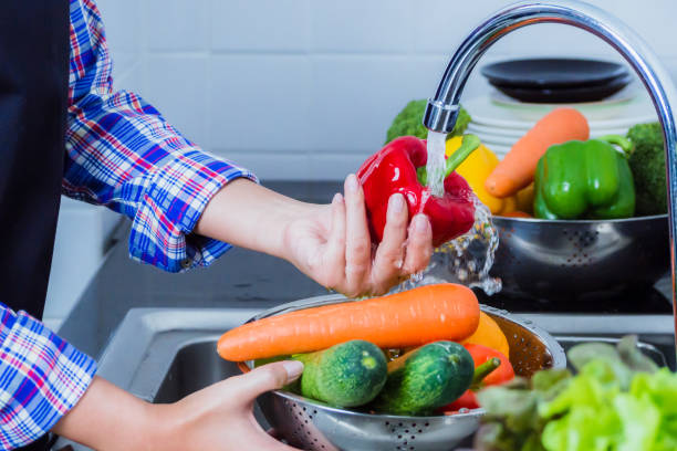 istock Washing fruit and vegetables to remove pesticides. 1196094486