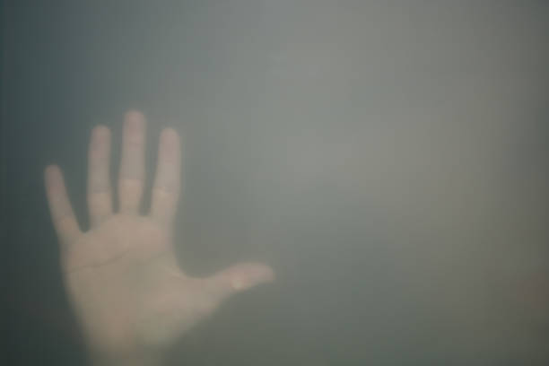 반투명 유리 뒤에 손을. 손 실루엣이 안개에. 외로움 개념. 손바닥이 유리 창에 닿습니다. - trapped horror fog human hand 뉴스 사진 이미지