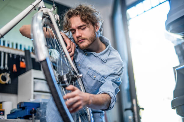 istock Young mechanic examining a damaged bicycle wheel. 1196097305