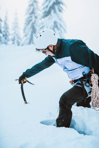 istock Male Alpinist Checking Snow Depth With Pickaxe 1196098159
