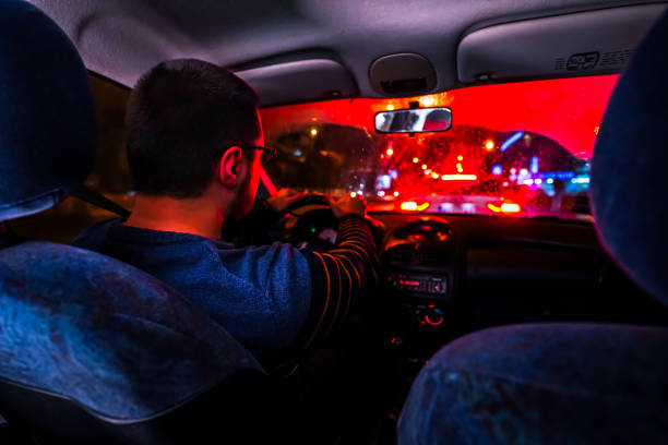 istock Man driving car at night in city 1196098721