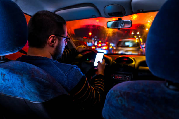 istock Man driving car and typing on mobile phone 1196098741