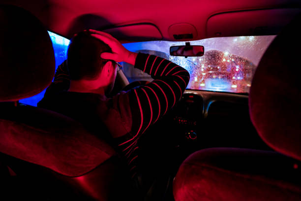 istock Worried Man driving car at night 1196098749